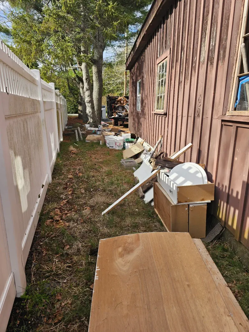 Side yard junk and debris piled up for removal near Barnstable MA