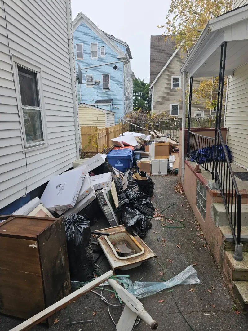 Driveway cleanout with furniture boxes and bags near Barnstable MA